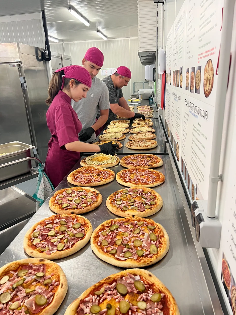 L’équipe garnit les pizzas au laboratoire